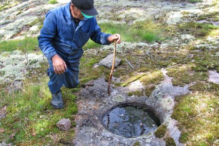 Mies mittaa oksalla hiidenkirnun syvyyttä